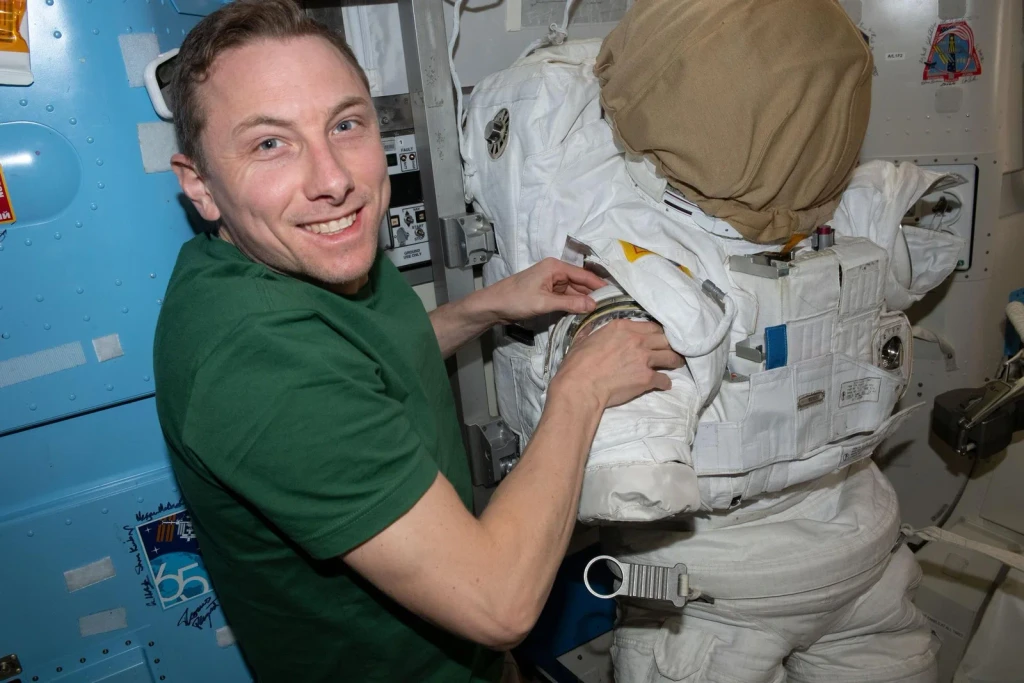 NASA astronaut Woody Hoburg prepares a spacesuit for a spacewalk, from Astronauts: Working in a Vacuum