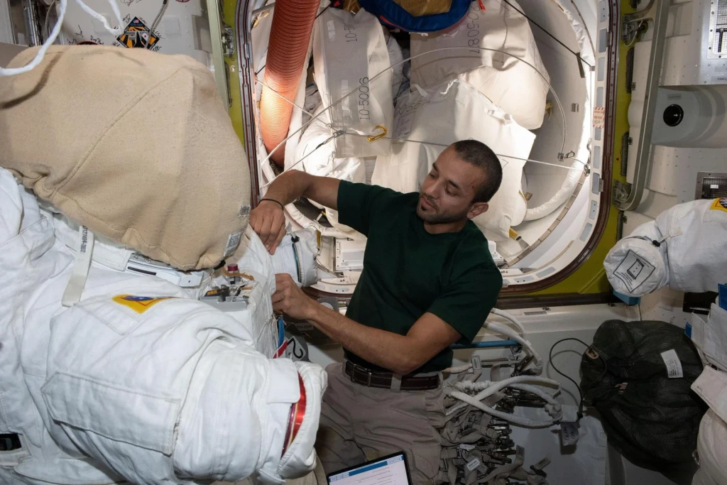 UAE astronaut Sultan Alneyadi prepares a spacesuit for a spacewalk, from Astronauts: Working in a Vacuum