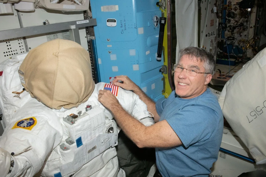 NASA astronaut Stephen Bowen prepares a spacesuit for a spacewalk, from Astronauts