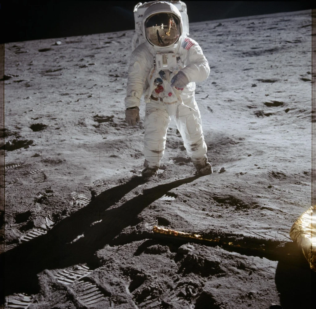 Astronaut Edwin Aldrin walks on lunar surface near leg of Lunar Module, from The Moon